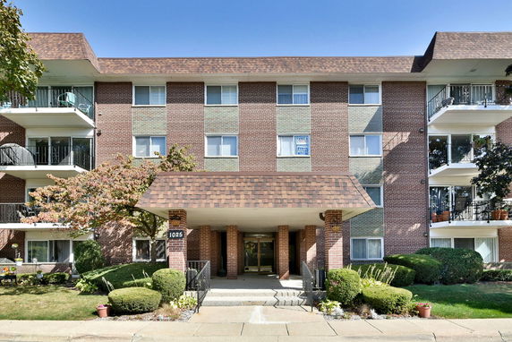 Front view of a multi-story brick building with balconies.