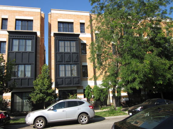 Front view of a multi-story building with brick facade and black window accents.