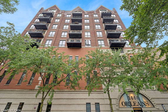 Front view of a multi-story brick building with balconies.