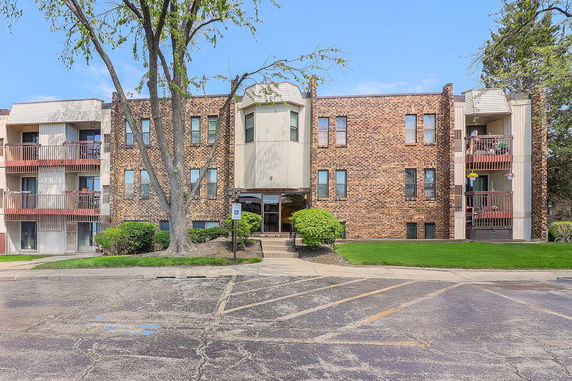 Front view of a three-story brick building with balconies.