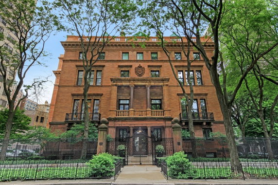 Front view of a large, multi-story brick building with ornate architectural details.