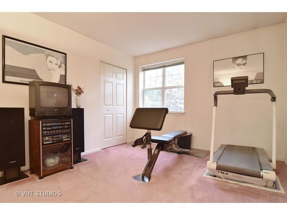 Home gym with a treadmill and other exercise equipment.