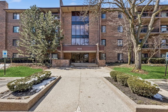 Front view of a multi-story brick building with a central entrance.
