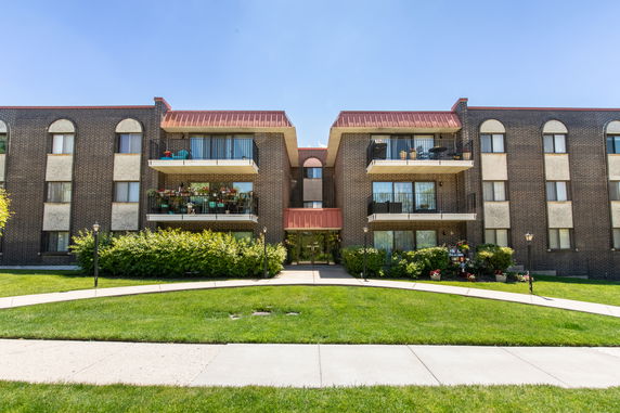 Front view of a three-story apartment building with balconies.