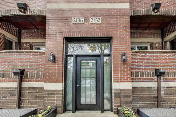 Front view of a brick building entrance with glass door.