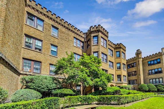 Front view of a multi-story brick building with decorative architectural elements.