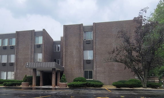 Front view of a three-story brick building with a covered entrance.