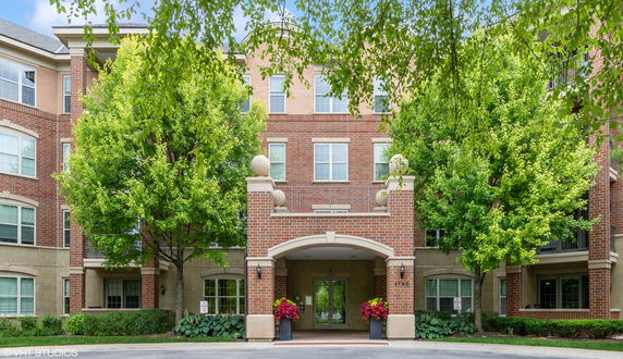 Front view of a multi-story brick building with an archway entrance.
