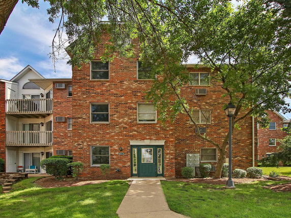 Front view of a multi-story brick apartment building.