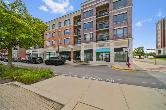 Front view of a multi-story commercial building with retail spaces and apartments.