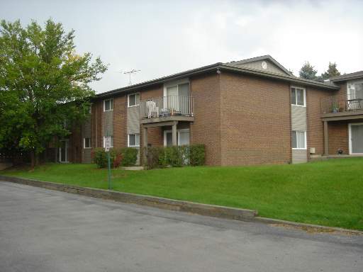 Front view of a two-story brick apartment building with balconies.