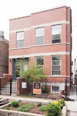 Front view of a two-story brick house with large windows.