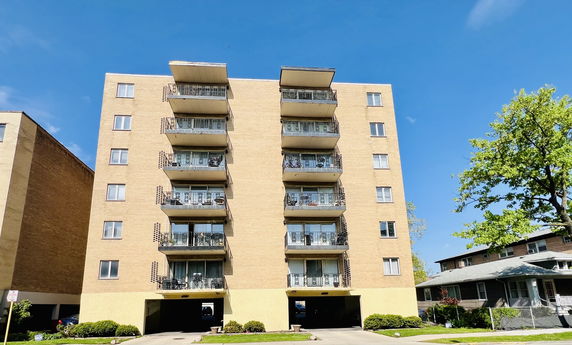 Front view of a multi-story apartment building with balconies.