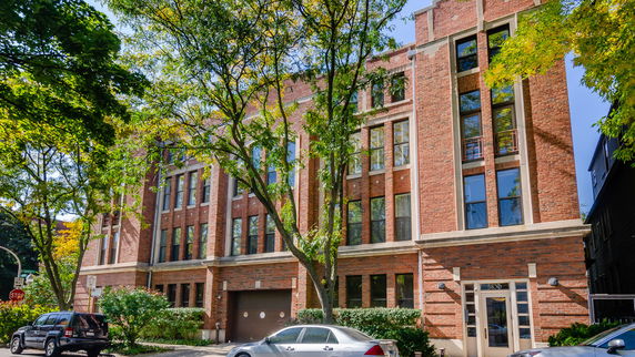 Front view of a brick building with large windows and multiple stories.