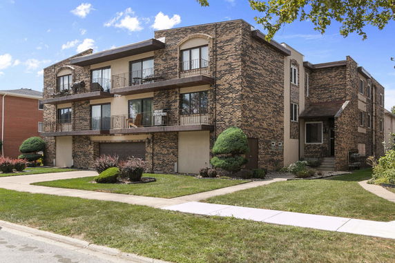 Front view of a two-story brick apartment building with balconies.