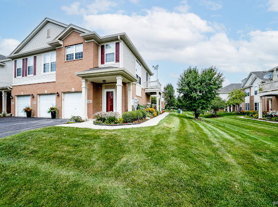 Front view of a two-story house with a brick facade and attached garage.