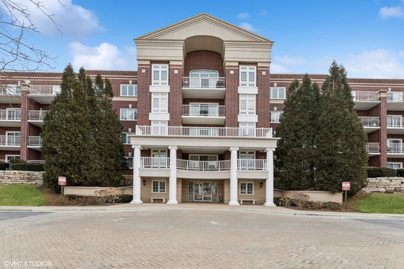 Front view of a multi-story building with balconies and a grand entrance.