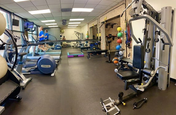 Indoor gym area with exercise equipment including treadmills and weight machines.
