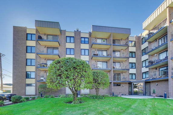 Front view of a multi-story apartment building with balconies.