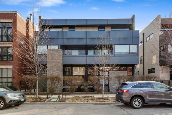 Front view of a modern multi-story building with a sleek design and large windows.