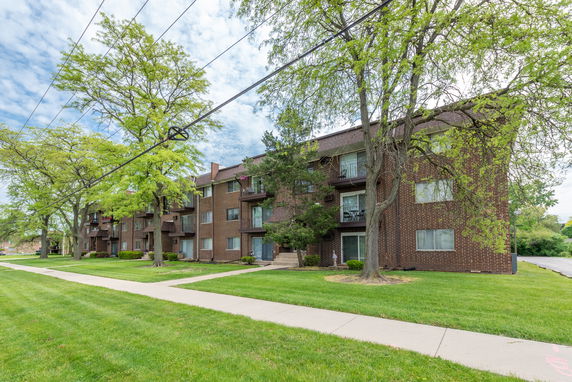 Front view of a multi-story apartment building with balconies.