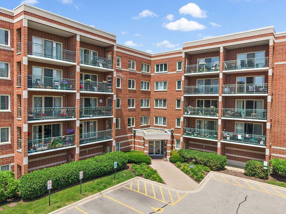 Front view of a multi-story apartment building with balconies.