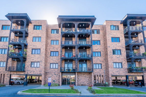 Front view of a multi-story apartment building with brick exterior and balconies.