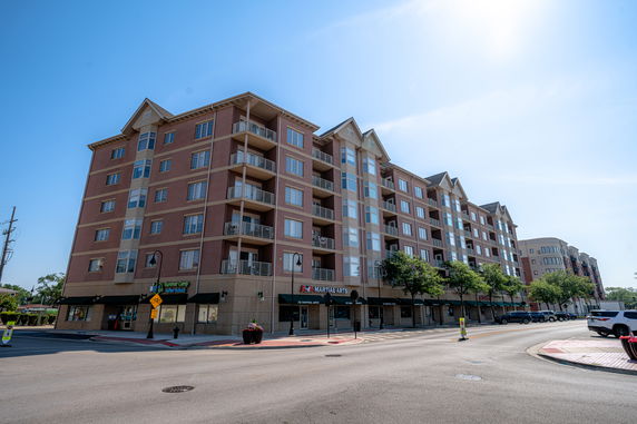 Front view of a multi-story building with retail spaces at the ground level.