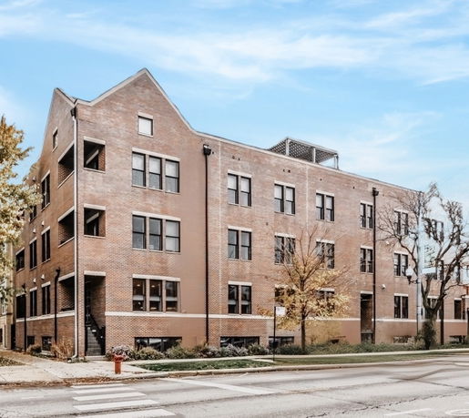 Front view of a multi-story brick building with multiple windows.