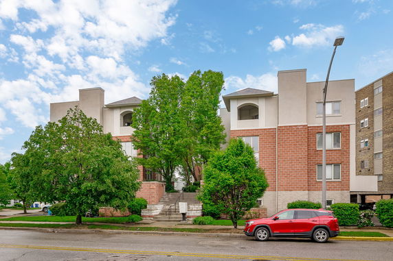 Front view of a multi-story building with a combination of brick and stucco facade.
