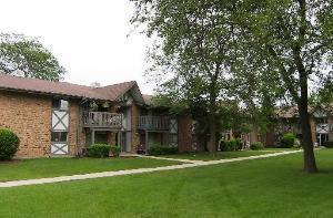 Front view of a residential building with balconies and brick exterior.