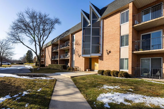 Front view of a multi-story apartment building with balconies.
