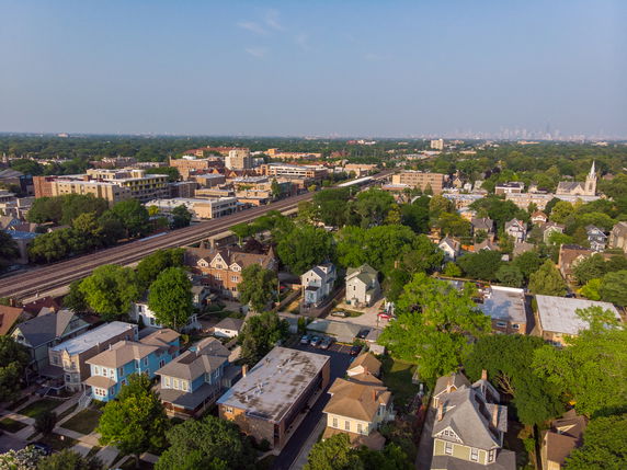 Aerial view of a suburban area with multiple houses and a railway line running through it.