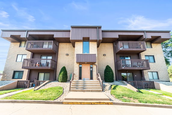 Front view of a multi-story apartment building with balconies.