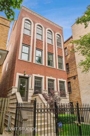 Front view of a three-story brick building with arched windows.