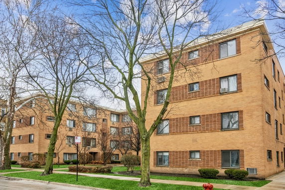Front view of a multi-story brick apartment building.