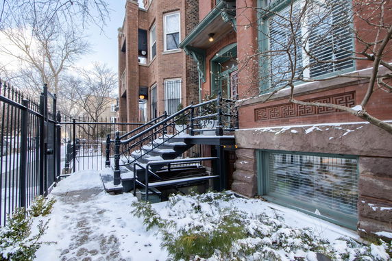 Front view of a multi-story brick building with ornamental metal stairs and railings.