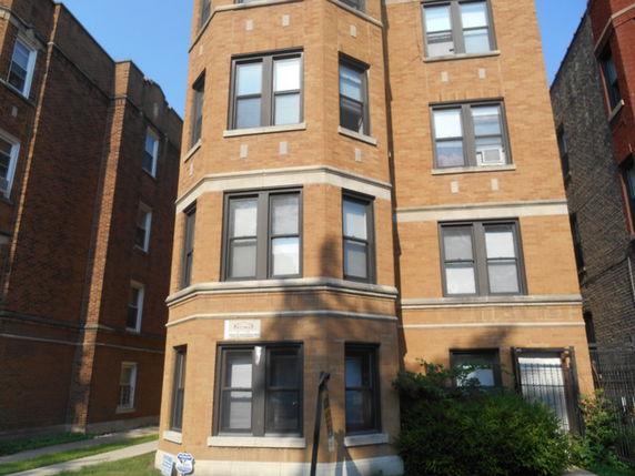 Front view of a multi-story brick apartment building.