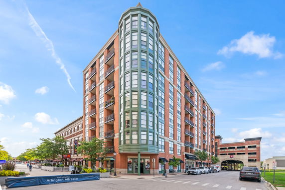 Front view of a multi-story brick building with large windows and balconies.