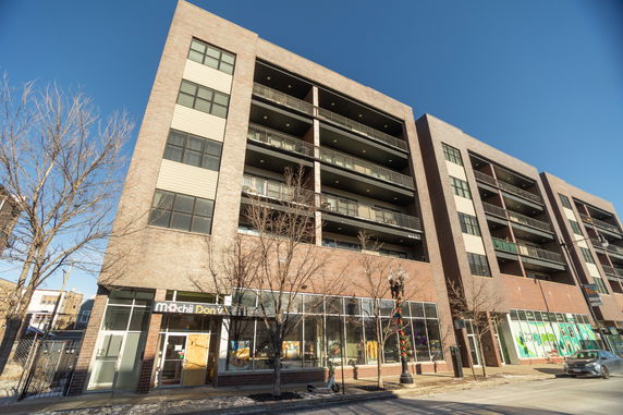 Front view of a multi-story commercial and residential building.