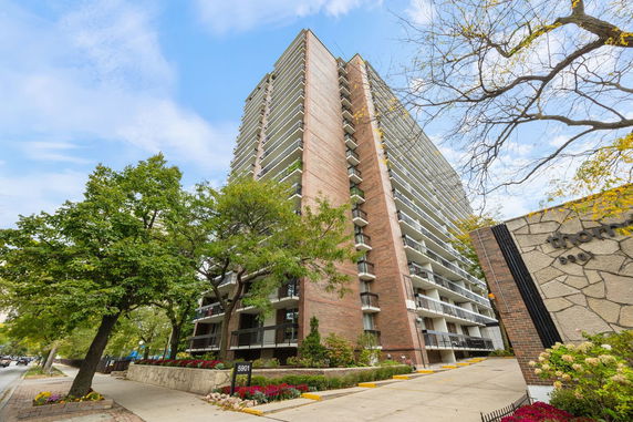 Front view of a tall apartment building with multiple balconies.