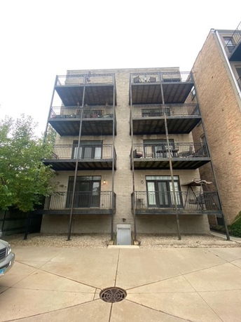Front view of a multi-story building with metal balconies.