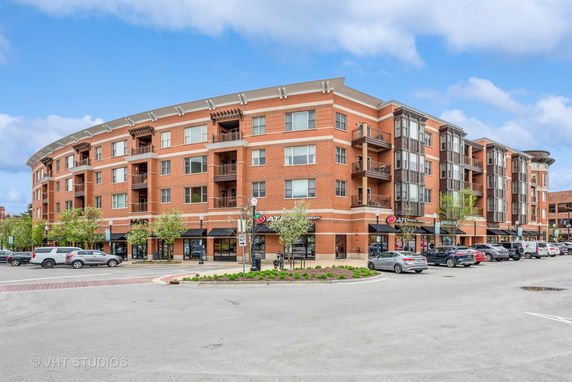 Front view of a multi-story brick building with retail spaces on the ground floor.