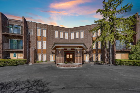 Front view of a multi-story brick building with a small entrance canopy.