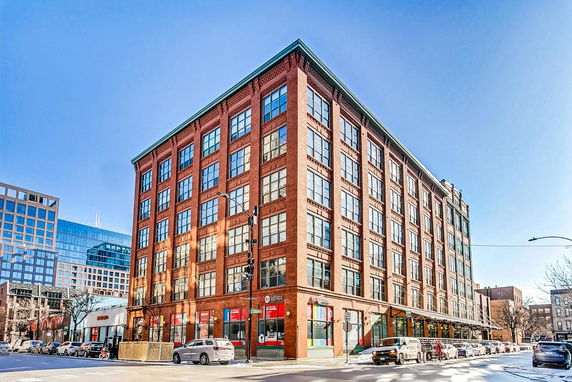 Front view of a multi-story brick building with large windows.
