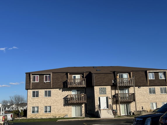 Front view of a multi-story apartment building with balconies.
