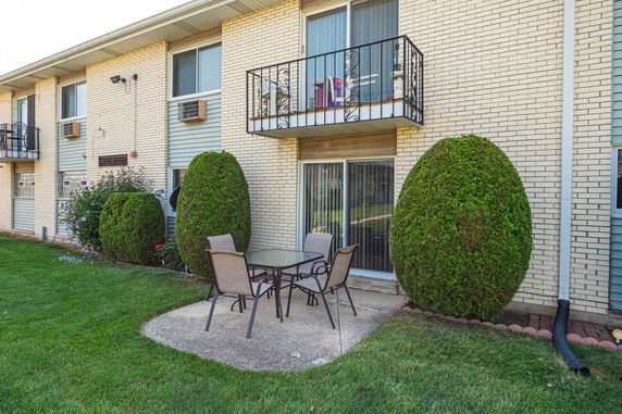 Exterior view of a two-story brick building with balconies and patio.