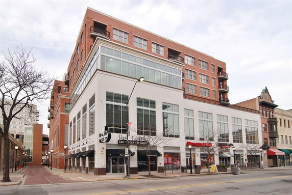 Front view of a multi-story commercial and residential building with ground-floor shops.