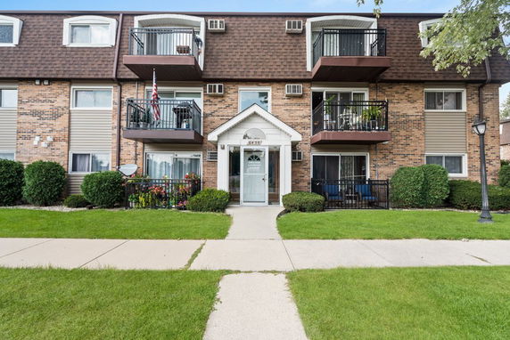 Front view of a three-story residential building with balconies.