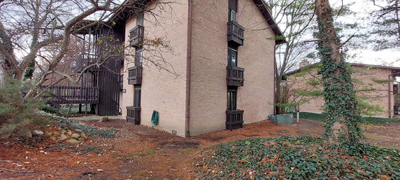 Corner view of a multi-story brick building with small balconies.